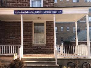 Side door of Homewood Meetinghouse. Banner reads "Quakers celebrating 100 years in Charles Village" 1921-2021
